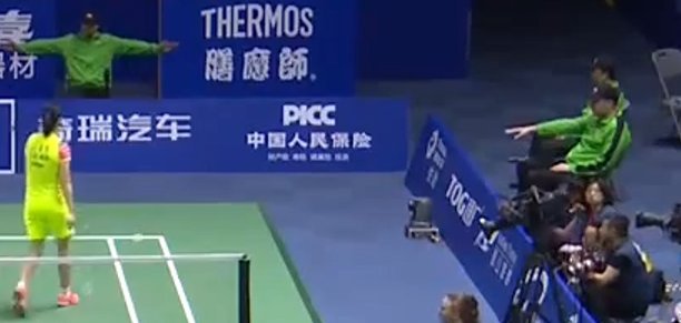 Two line judges showing different signs